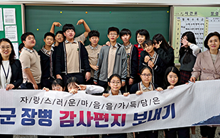 교실 앞에서 중학생들이 현수막 들고 단체사진 찍은 모습