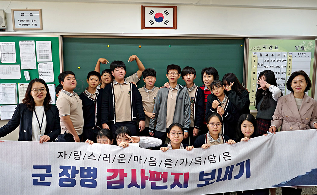교실 앞에서 중학생들이 현수막 들고 단체사진 찍은 모습