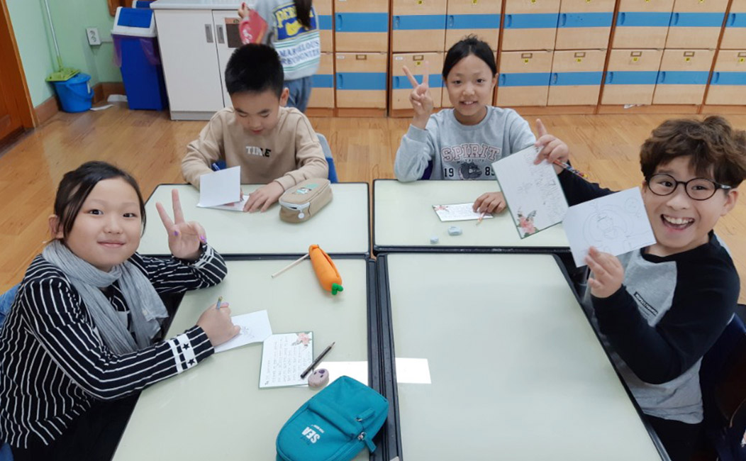 편지를 작성하고 있는 아이와 다 작성한 아이들의 모습