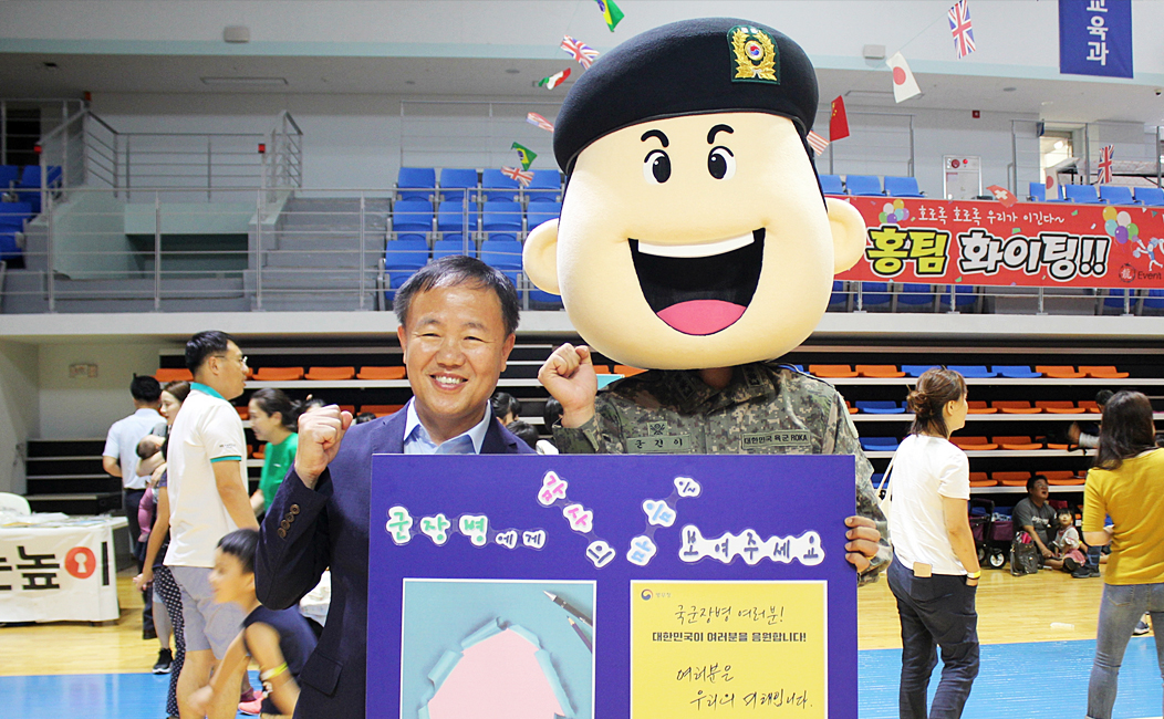 굳건이(병무청캐릭터)와 성인남자 감사편지 판넬을 들고 응원하는 모습