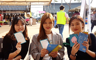 세명의 여성이 나란히 앉아 편지를 들고웃고 있는 모습