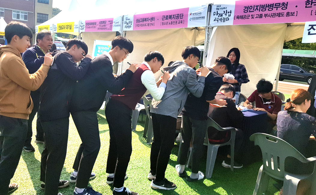 남자 청소년들이 서로서로 등을 지지대 삼아 감사편지를 쓰고있는 모습