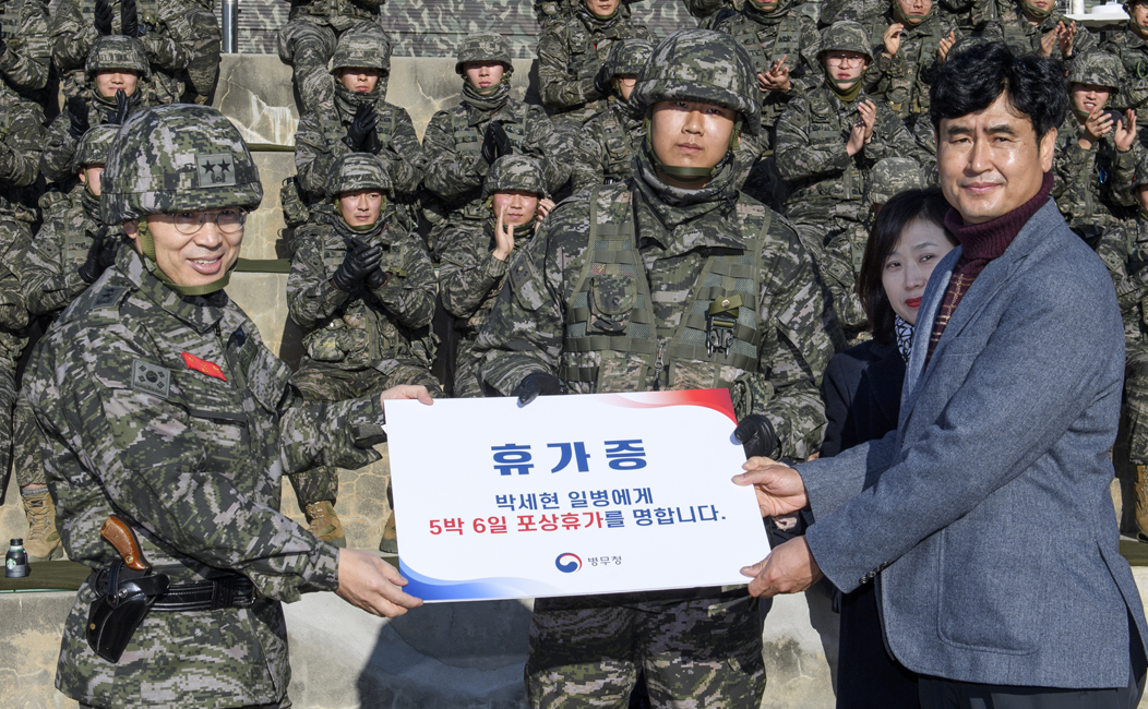 휴가증을 박세현 일병과 아버지, 어머니가 전달 받는 모습