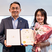 일반부문 대상수상자가 상장과 꽃을 들고 병무청장과 나란히 서있는 모습
